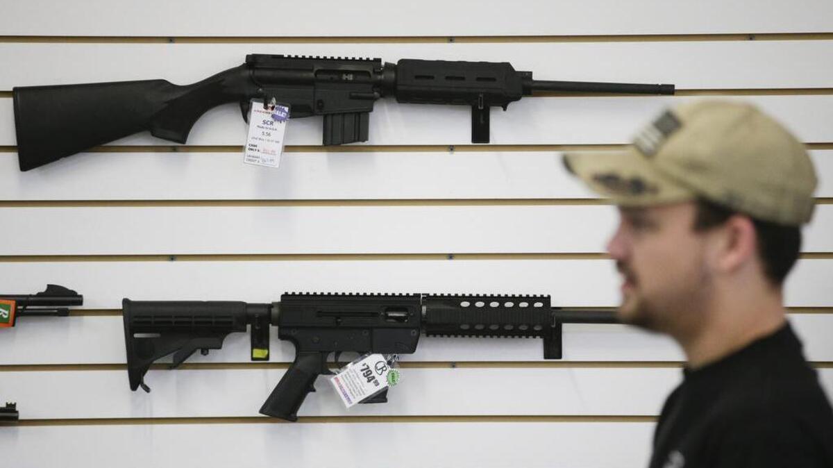 A sales associate walks past semiautomatic rifles at Bullseye Sport gun shop in Riverside, Calif. The massacre at Sandy Hook Elementary School in which a mentally disturbed young man killed 26 children and teachers galvanized calls across the nation for tighter gun controls. But in the three years since, many states have moved in the opposite direction, embracing the National Rifle Association’s response that more “good guys with guns” are what’s needed to limit the carnage of mass shootings.