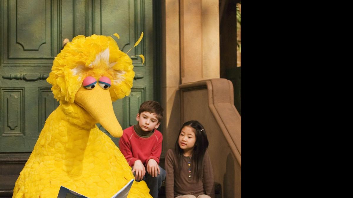 
Muppet character Big Bird reads to Connor Scott and Tiffany Jiao during a taping of the children’s program “Sesame Street” in New York in 2008. Sesame Street’s impact on its young viewers is comparable to that of preschool, according to a new study.
