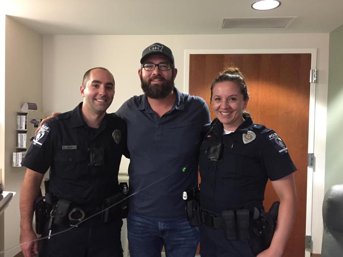 “It was special to be out of the bed and be able to take a photo, get a good photo with both of them where I’m still connected to the IV but sort of sandwiched between them and with big smiles,” says John Ogburn, shown with Charlotte Mecklenburg Police Officers Lawrence Guiler and Nikolina Bajic on July 4 at Novant Health Presbyterian Medical Center.