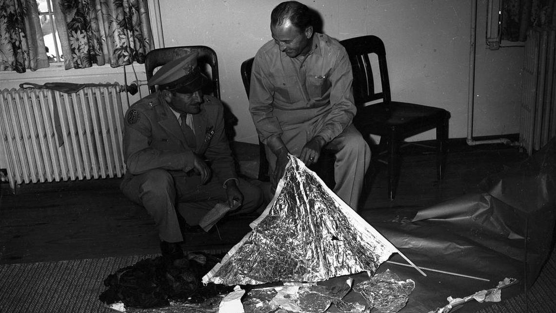 Brig. Gen. Roger Ramey, 8th Air Force commander, left, and Col. Thomas J. Dubose, chief of staff, look over debris flown to Fort Worth Army Air Field (now Naval Air Station Fort Worth) from a mysterious crash near Corona, N.M., in June, 1947. The text on the paper in Ramey’s hand is being studied.