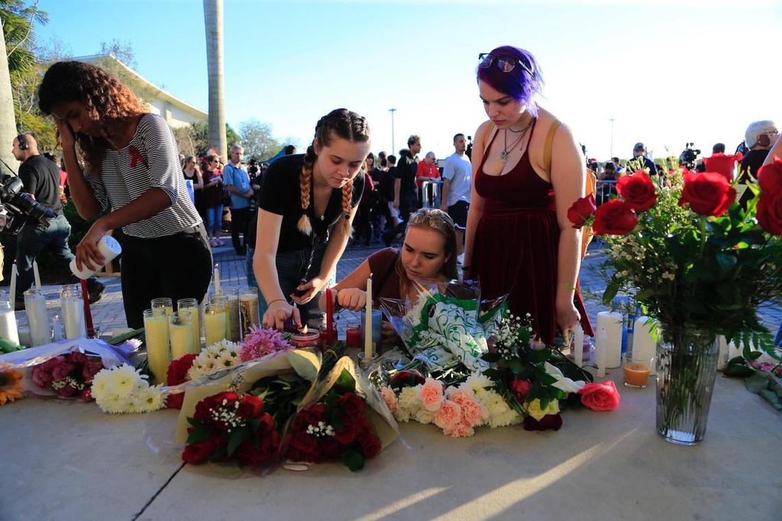 Teenagers light candles during a vigil at Pine Trails Park for victims of the shooting at Marjory Stoneman Douglas High School