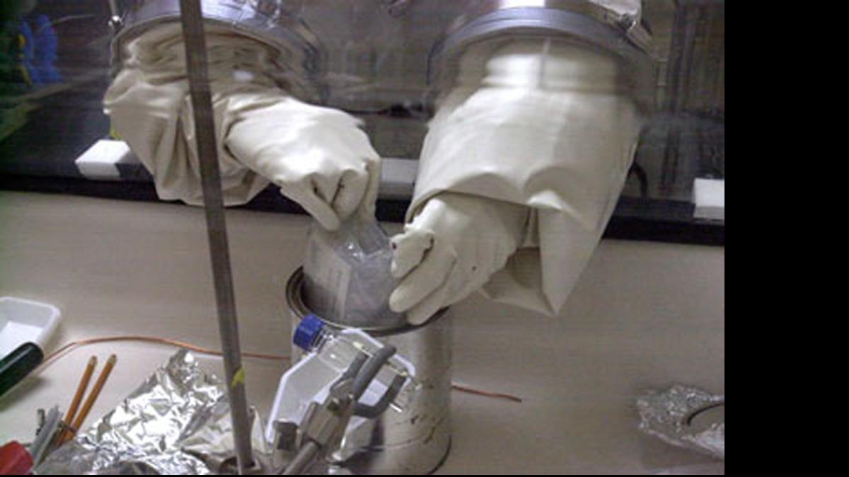 
A letter believed tainted with anthrax spoes is removed from a protective container to be opened at Ft. Detrick, Maryland, on December 5, 2001. 
