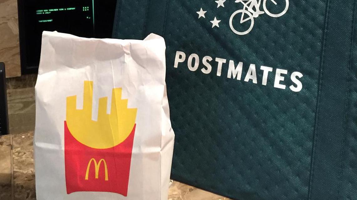 A bag of food from McDonald's ordered through the Postmates service sits next to a Postmates delivery bag during a delivery in New York on Wednesday, May 6, 2015.