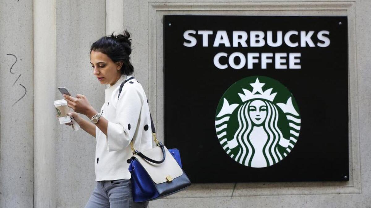 
A woman walks out of a Starbucks Coffee with a beverage in hand in New York in July 2015. Coffee prices jumped 6.1 percent in January from 12 months earlier, the most in nearly three years. Starbucks has responded by raising the price of a cup of coffee by between 5 cents and 20 cents. 
