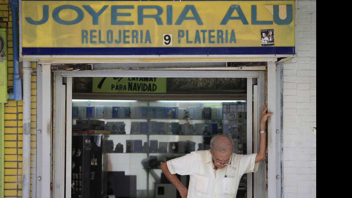 
A man stands in front of a jewelry store in the neighborhood of Rio Piedras in San Juan, Puerto Rico, Monday, June 29, 2015. The jewelry itself is surrounded by closed down businesses. International economists released a critical report on Puerto Rico's economy Monday on the heels of the governor's warning that the island can't pay its $72 billion public debt.
