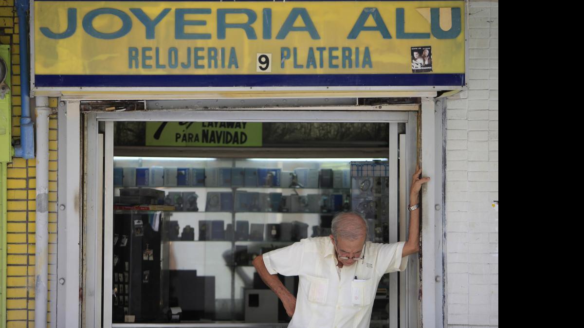 
A man stands in front of a jewelry store in the neighborhood of Rio Piedras in San Juan, Puerto Rico, Monday, June 29, 2015. The jewelry itself is surrounded by closed down businesses. International economists released a critical report on Puerto Rico's economy Monday on the heels of the governor's warning that the island can't pay its $72 billion public debt.
