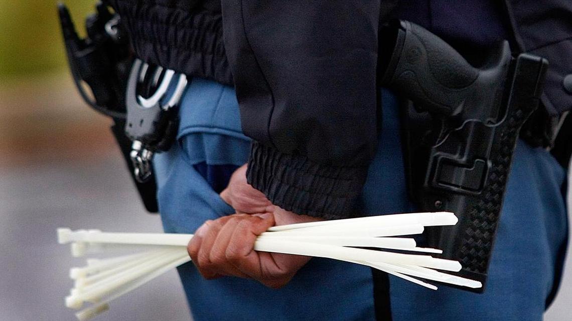 An officer holds a group of plastic zip ties to use as handcuffs. Police in Vail, Colorado, found a woman in a dumpster Tuesday morning tied up with zip ties.