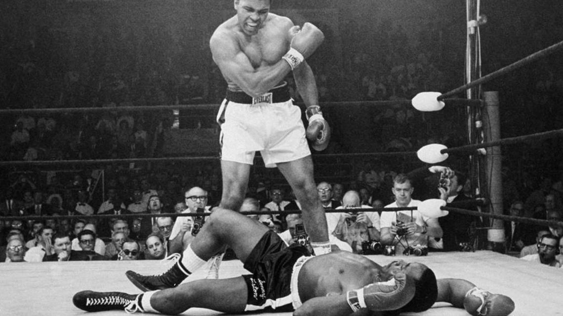 Muhammad Ali, then known as Cassius Clay, stands over challenger Sonny Liston in this iconic 1965 photo. Ali, whose fast fists and irrepressible personality transcended sports and captivated the world, died Friday at the age of 74.