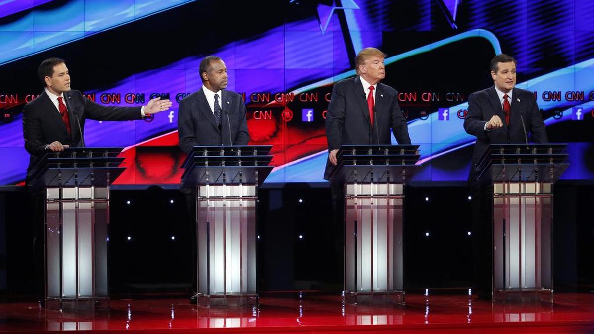 Marco Rubio, left, and Ted Cruz, right, both speak as Ben Carson, second from left, and Donald Trump, second from right, look on during the CNN Republican presidential debate at the Venetian Hotel & Casino on Tuesday.