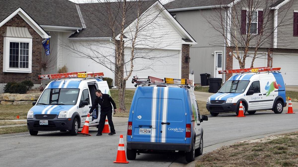 Workers install Google Fiber March 19, 2013 in a neighborhood near Kansas City, Kansas.