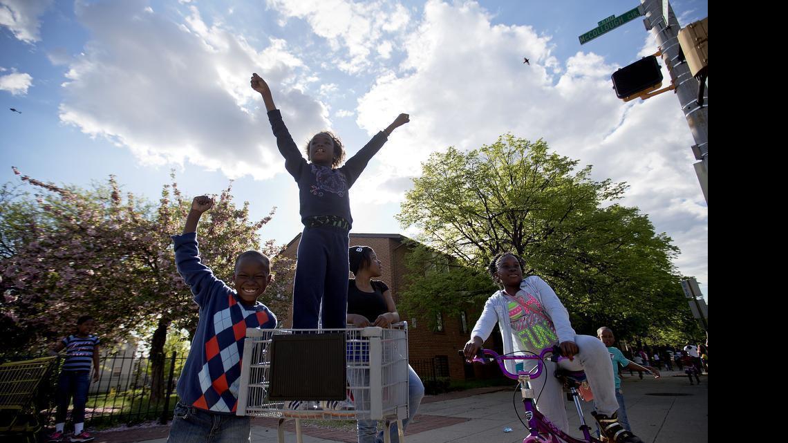 
Children cheer as demonstrators march the day after charges were announced against the police officers involved in Freddie Gray's death, Saturday, May 2, 2015, in Baltimore. 
