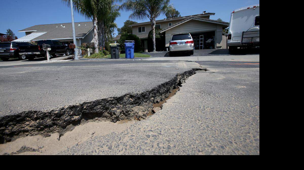 
A crack in the pavement caused by an earthquake cuts across the street in a neighborhood of Napa, Calif.
