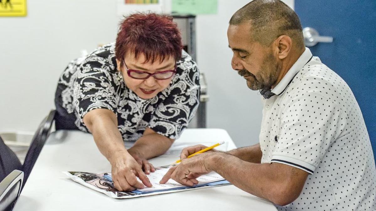 Rocio Ramsey, left, helps Ahmad Alabood in her English class in Kansas City, Mo. Alabood and his family recently settled in Kansas City after fleeing the violence plaguing their native Syria and are now learning more about the language and American culture.