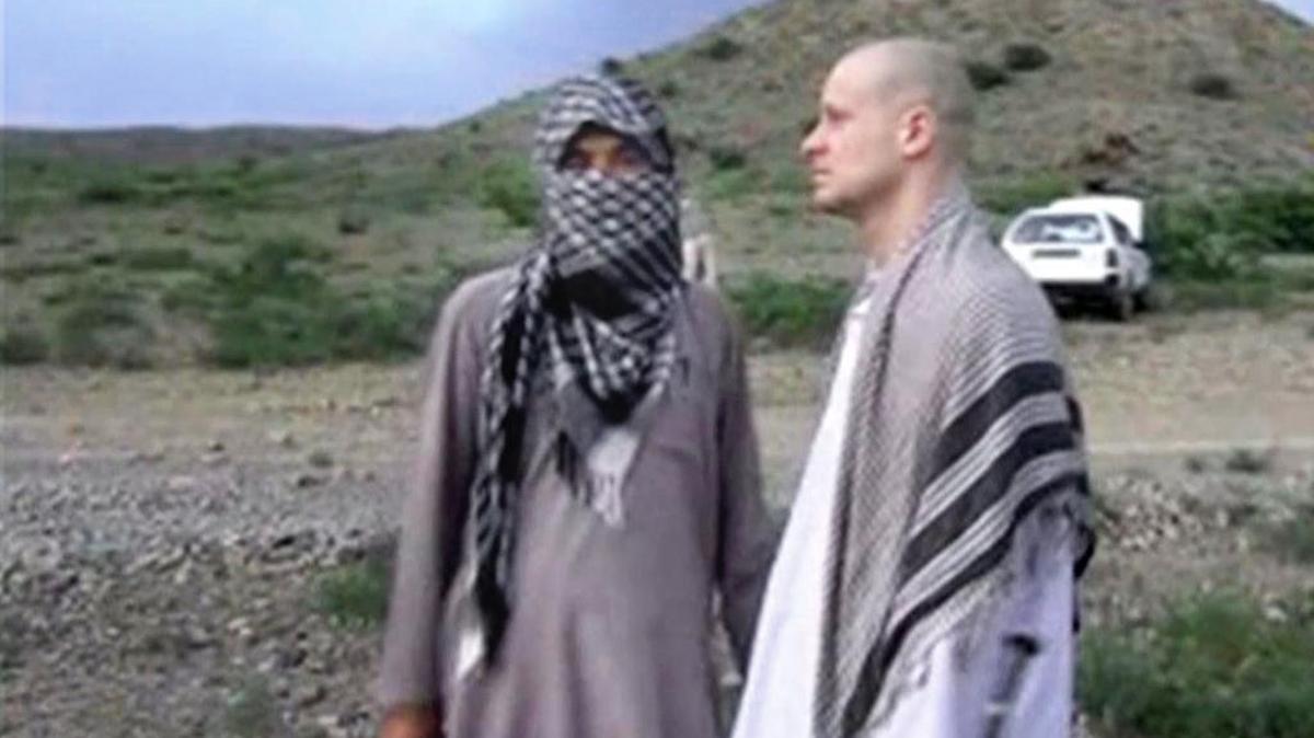 In this Saturday, May 31, 2014, image made from video obtained from the Voice Of Jihad website, which has been authenticated based on its contents and other AP reporting, U.S. Army Sgt. Bowe Bergdahl, right, stands with a Taliban member in eastern Afghanistan. The first episode of Serial’s second season starts by recounting the events of this video, which featured Bergdahl being handed back over to U.S. authorities.