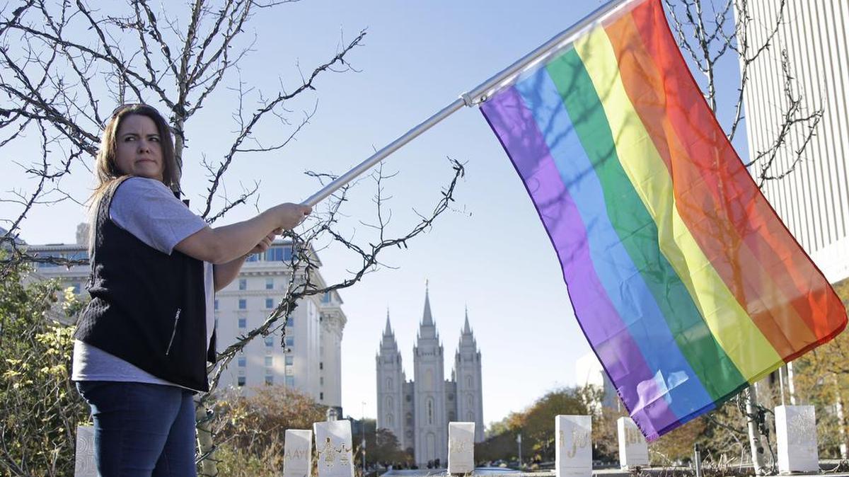Sandy Newcomb stands with a rainbow flag as Mormons gather for a mass resignation from The Church of Jesus Christ of Latter-day Saints on Nov. 14, 2015, in Salt Lake City. Mormon leaders are telling gay and lesbian church members that attraction to people of the same sex is not a sin or a measure of their faithfulness. But they are reminding those members that acting on those feelings by having sex violates fundamental doctrinal beliefs that won’t change. The message is part of the Mormon church’s “Mormon and Gay” website launched Tuesday, Oct. 25, 2016, with dozens of articles, teachings, videos and stories from Mormons who identify themselves as gay.
