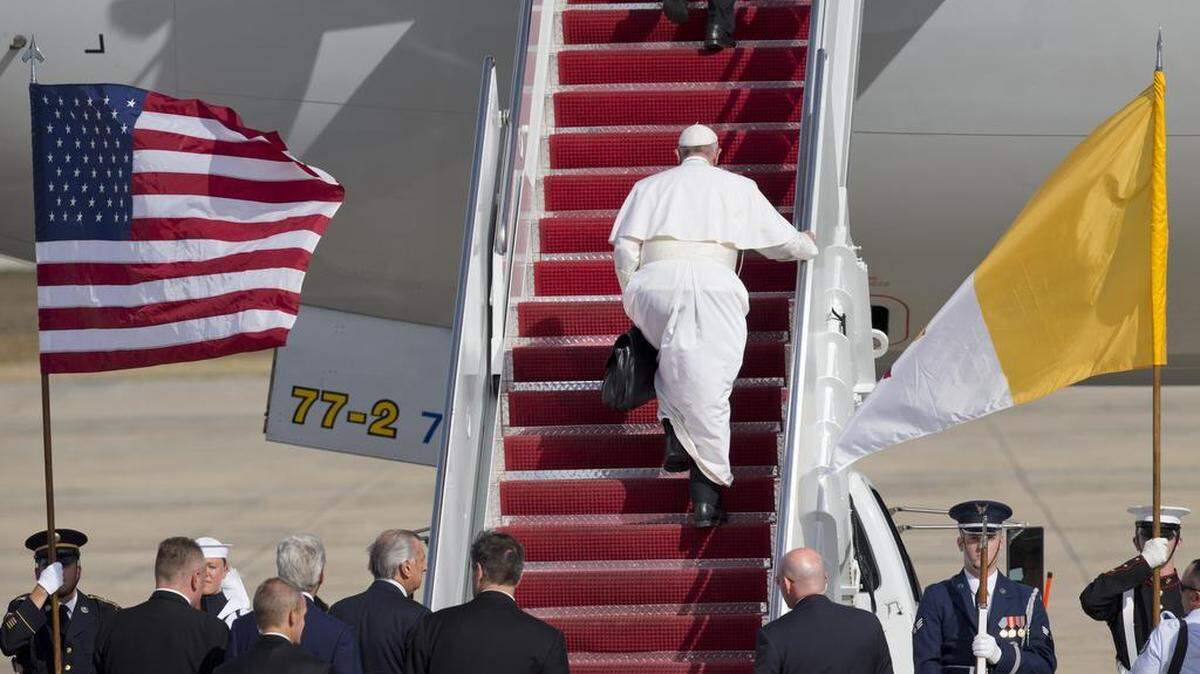 
Pope Francis carries his briefcase up the stairs of his plane before leaving from Andrews Air Force Base, Md., en route to New York, Thursday, Sept. 24, 2015. 
