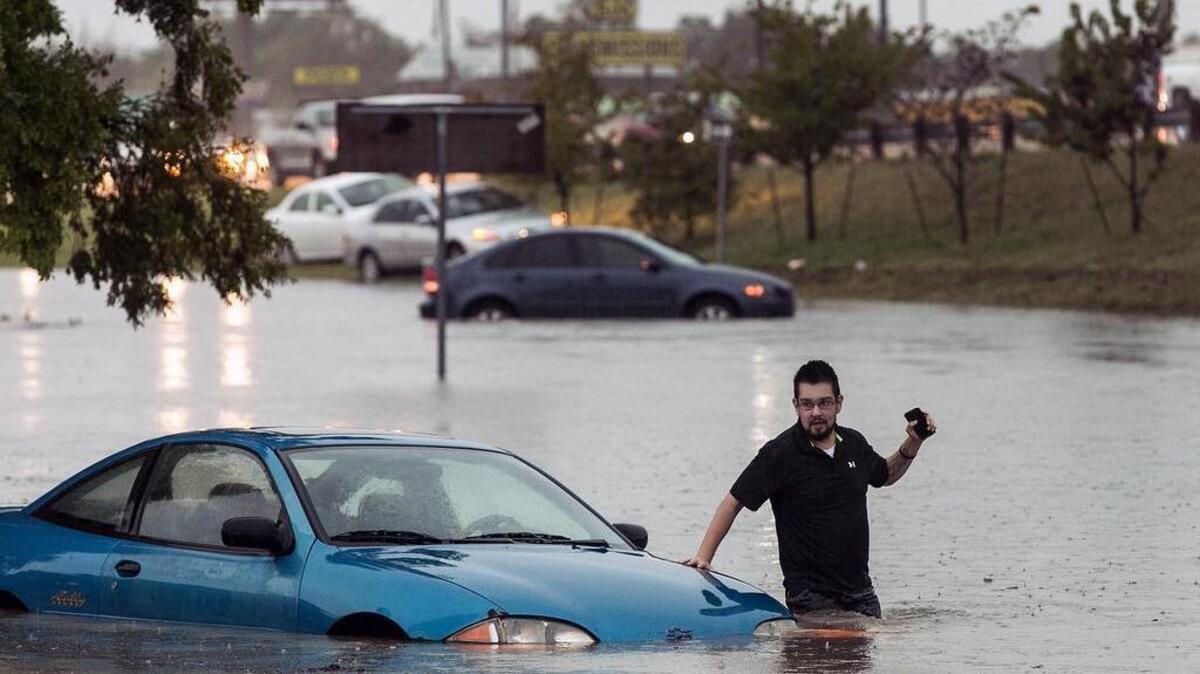 Mike Stoner gets out of his flooded car, Friday, Oct. 30, 2015, in San Marcos, Texas. A fast-moving storm packing heavy rain and destructive winds overwhelmed rivers and prompted evacuations Friday in the same area of Central Texas that saw devastating spring floods.