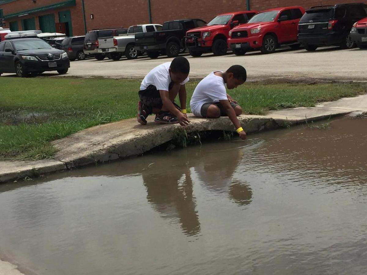 Jude McFarland’s two sons, ages 9 and 8, play outside a shelter in San Antonio, Texas. McFarland’s oldest child, Miracle, was born in New Orleans during Hurricane Katrina.