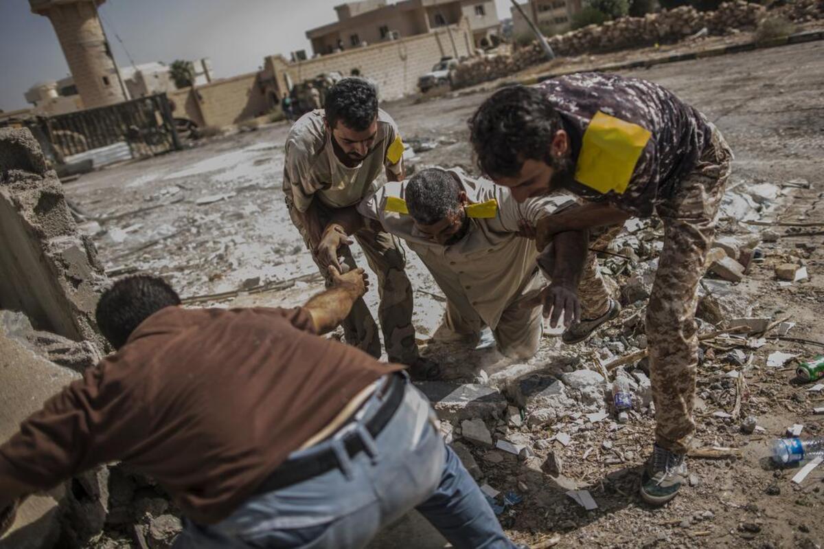 A fighter of the Libyan forces affiliated to the Tripoli government is helped by comrades after being shot by a sniper, in Sirte, Libya, Sunday, Oct. 2, 2016. A sniper also fatally shot a Dutch photojournalist on Sunday in the Libyan city of Sirte, the Islamic State's last bastion in the chaos-wracked North African country.