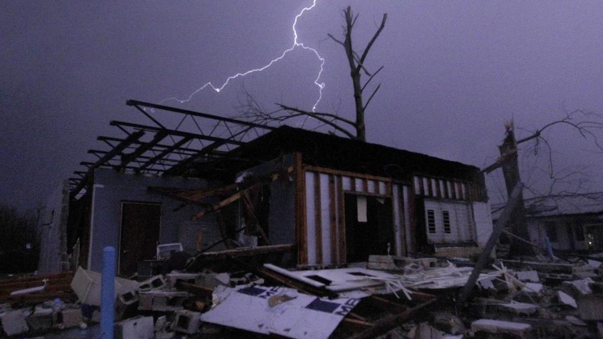 Lightning illuminates a house after a tornado touched down in Jefferson County, Ala., damaging several houses, Dec. 25, 2015, in Birmingham, Ala. A Christmastime wave of severe weather continued Friday.