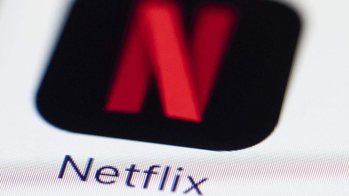 This July 2017 photo shows a Netflix logo on an iPhone in Philadelphia. The company will soon offer an ad-supported plan.