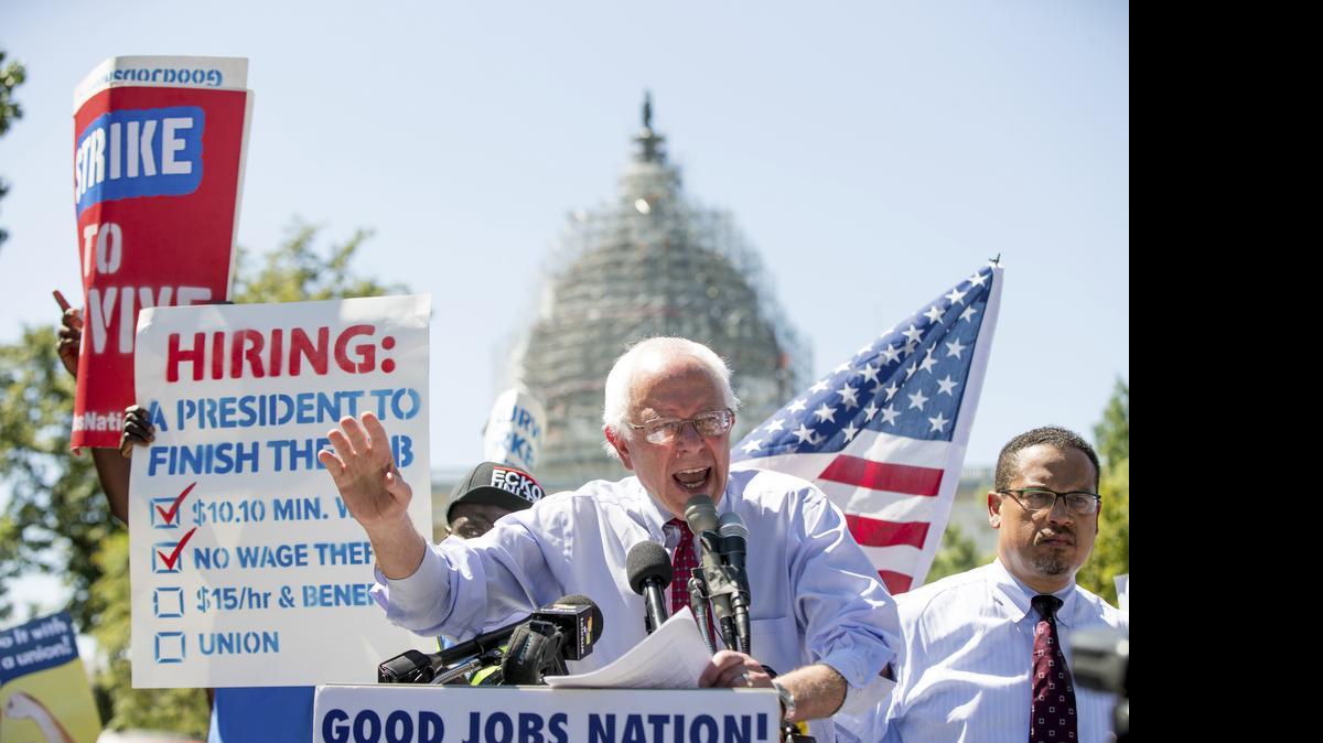 
Democratic presidential candidate Sen. Bernie Sanders, I-Vt., joined by federal contract workers, speaks during a rally on Capitol Hill in Washington on Wednesday, July 22, 2015, to push for a raise to the minimum wage to $15 an hour. 
