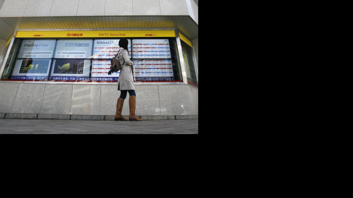 
 A passerby looks at Japan’s Nikkei stock prices displayed on an electronic board on March 11, 2015, in Tokyo. The Treasury Department reported April 15, 2015, that Japan in February held more than $1.224 trillion in U.S. government securities. 
