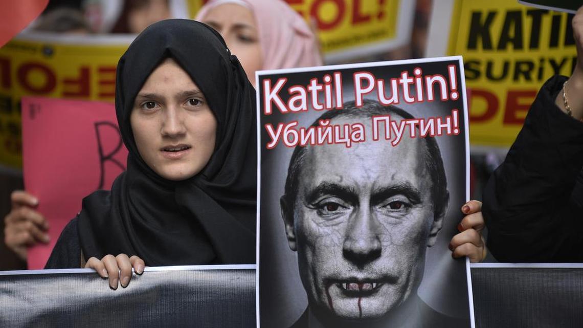 
An anti-Russian demonstrator in Istanbul, Turkey, Saturday held up a caricature of Russian President Vladimir Putin during a protest against Russian military operations in Syria. The picture reads in Turkish and Russian: “Murderer Putin.” 

