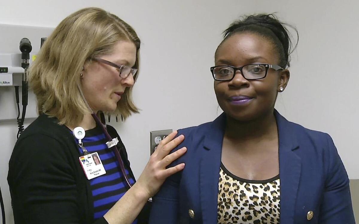 Dr. Anna Groskin, left, examines a patient at the Codman Square Health Center in Boston's Dorchester neighborhood. At one health center in Boston, primary care physicians, internists and psychologists prescribe access to a gym for $10 a month.