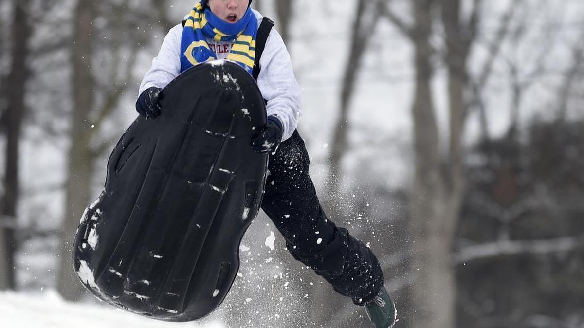 Abby Weber, 18, of Newburgh, Ind., goes airborne after hitting a ramp made out of snow while sledding after a winter storm brought about 3 inches of snow and closed schools.