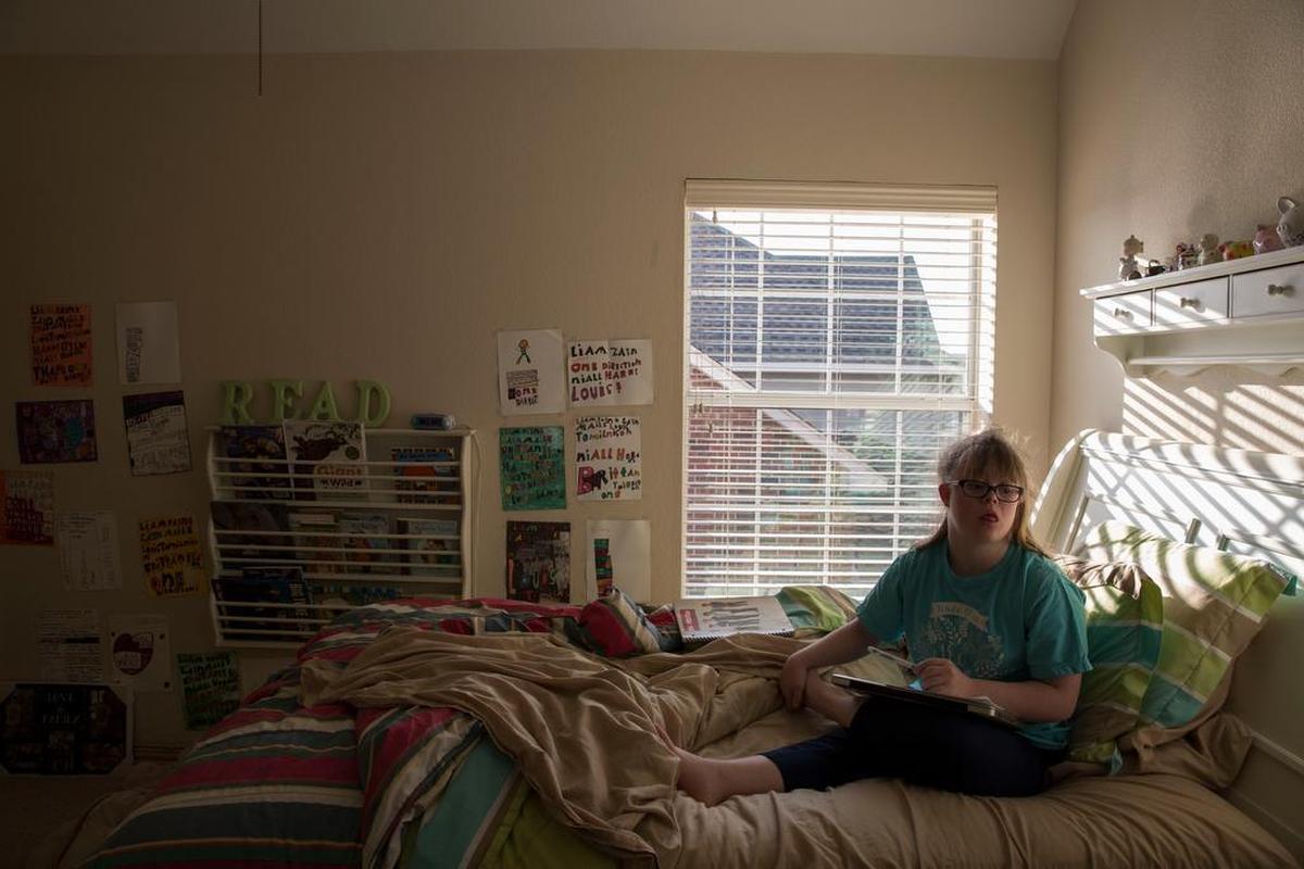 Brittany Lowe, 16, watches a movie in her room after competing in the NCA All-Star National Championship with her team, Texas Cheer Allstars, in the special athlete division. Lowe, who was born with Down Syndrome, has been cheering on an all special needs team since age 5.