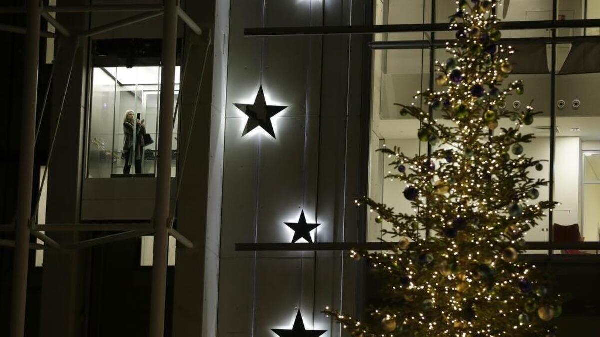A woman inside an elevator takes a photograph of a Christmas tree in southern Athens, on Thursday Dec. 22, 2016. (AP Photo/Thanassis Stavrakis)