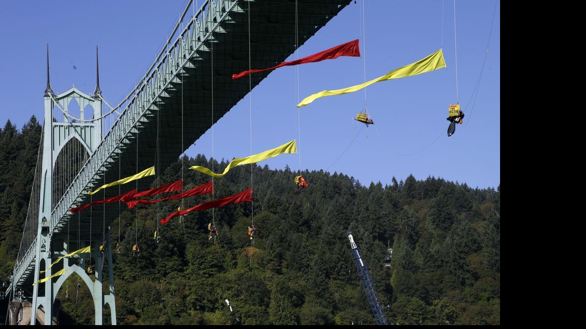 
Activists hang from the St. Johns bridge in an effort to block the Royal Dutch Shell PLC icebreaker Fennica from leaving for Alaska in Portland, Ore., Thursday, July 30, 2015. The icebreaker, which is a vital part of Shell's exploration and spill-response plan off Alaska's northwest coast, stopped short of the hanging blockade, turned around and sailed back to a dock at the Port of Portland. 
