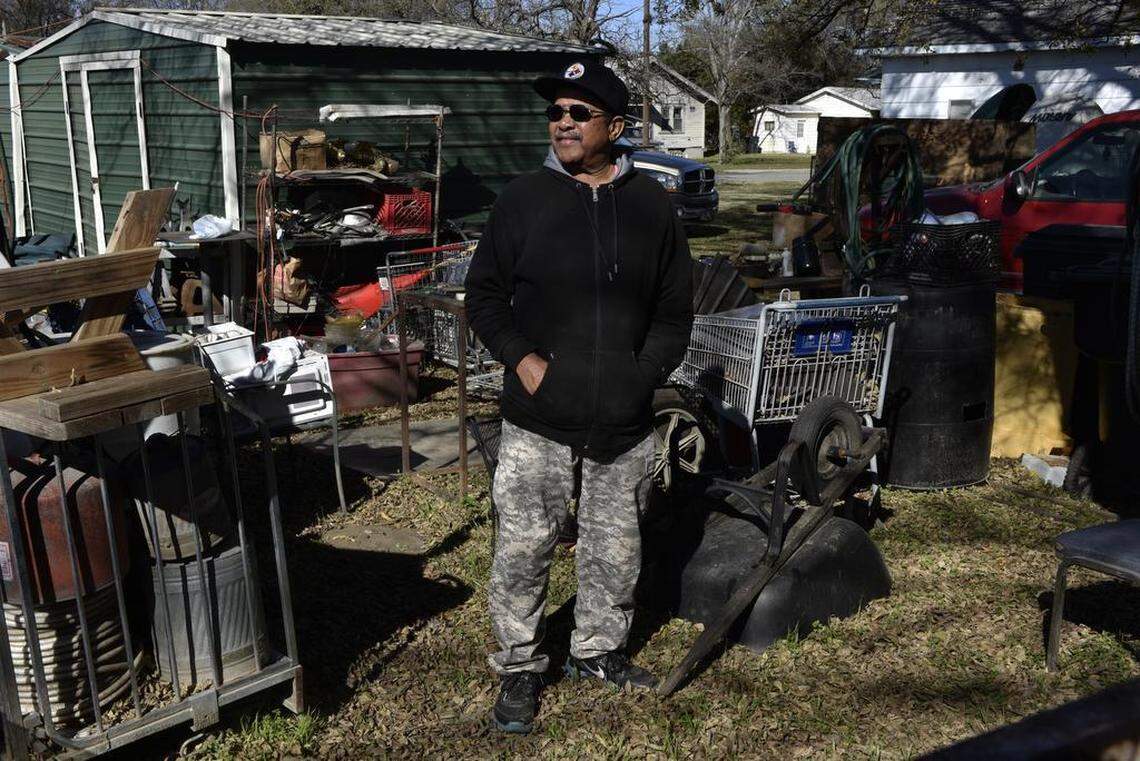 Leon Ray stands amid a collection of junk that he restores and recycles at his home in Claremore, Oklahoma.