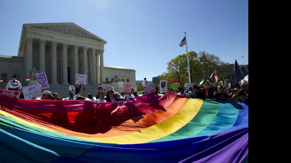 
In this April 28, 2015, file photo, demonstrators stand in front of a rainbow flag of the Supreme Court in Washington, as the court was set to hear historic arguments in cases that could make same-sex marriage the law of the land. Gay and lesbian couples could face legal chaos if the Supreme Court rules against same-sex marriage in the next few weeks. Same-sex weddings could come to a halt in many states, depending on a confusing mix of lower-court decisions and the sometimes-contradictory views of state and local officials. Among the 36 states in which same-sex couples can now marry are 20 in which federal judges invoked the Constitution to strike down marriage bans. 
