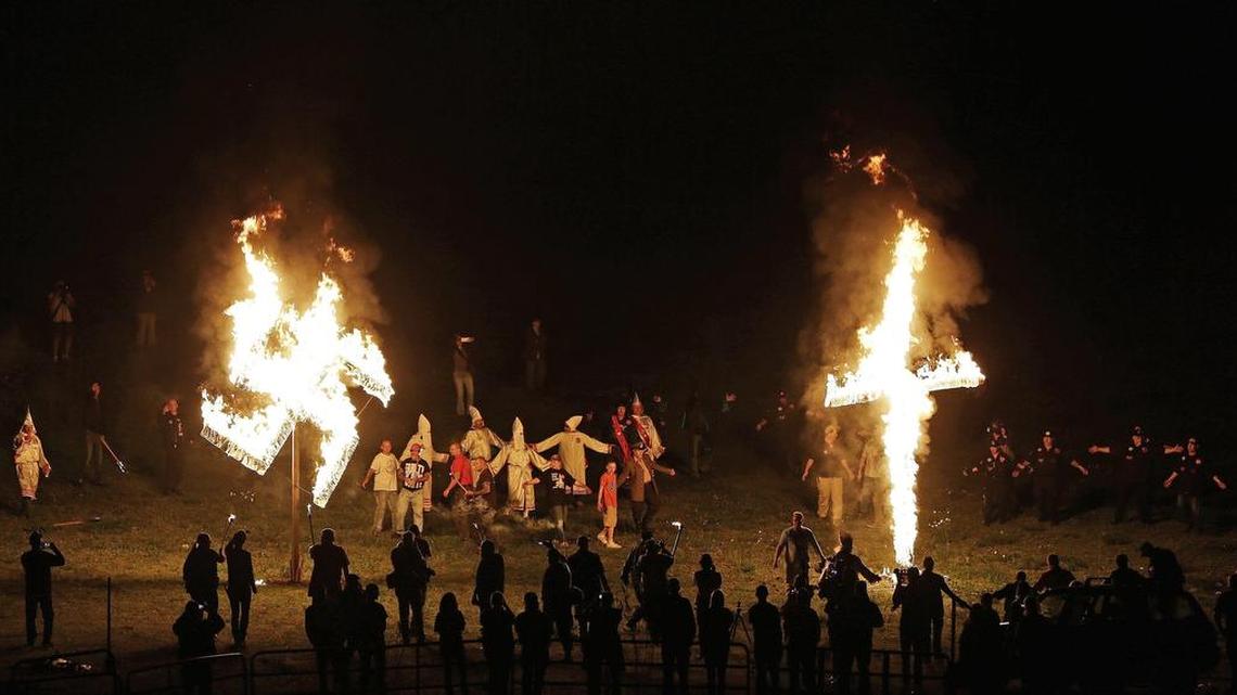 In this Saturday, April 23, 2016 photo, members of the Ku Klux Klan participate in cross and swastika burnings after a “white pride” rally in rural Paulding County near Cedar Town, Ga. White nationalists appear to have devised a new code for use on social media as a way to spread their views publicly without risk of being banned.