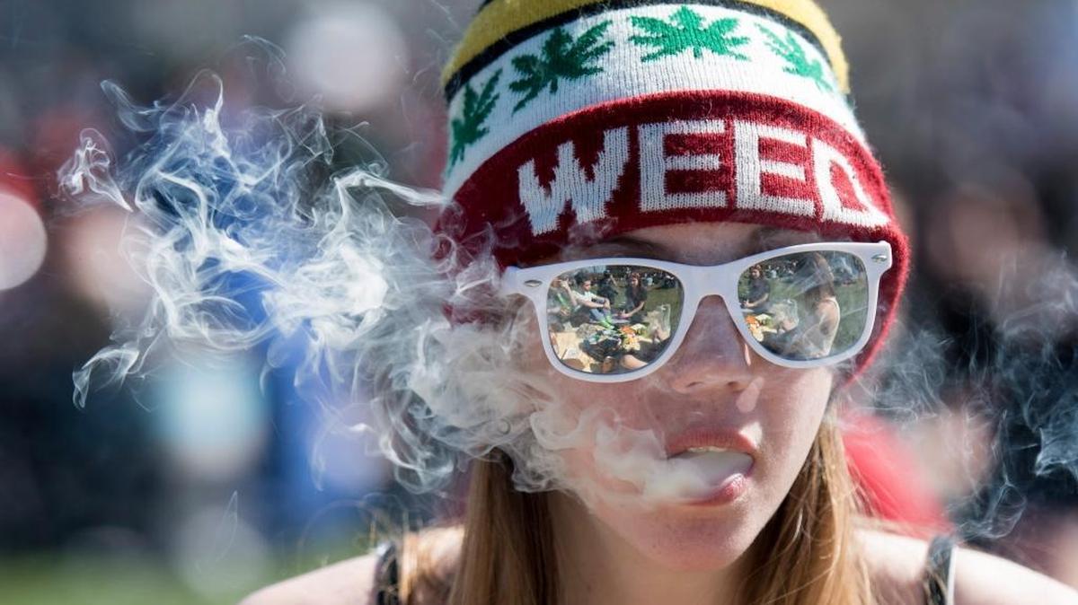 A woman exhales marijuana smoke during the annual 420 pot rally on Parliament Hill in Ottawa, Canada, on April 20, 2016.