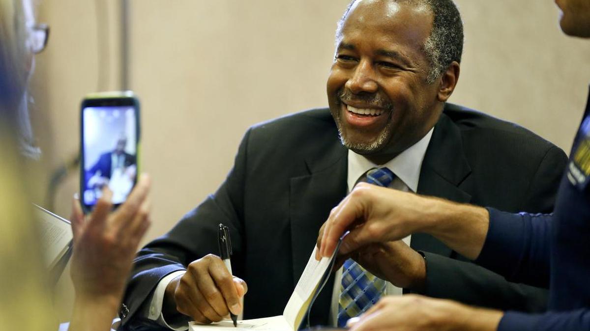 Republican presidential candidate Ben Carson signs a copy of his book “A More Perfect Union” on Friday, Oct. 23, 2015, at Barnes & Nobel in Topeka, Kan. Carson is surging in the polls. In Iowa he has a strong lead and, more importantly, big favorability numbers.