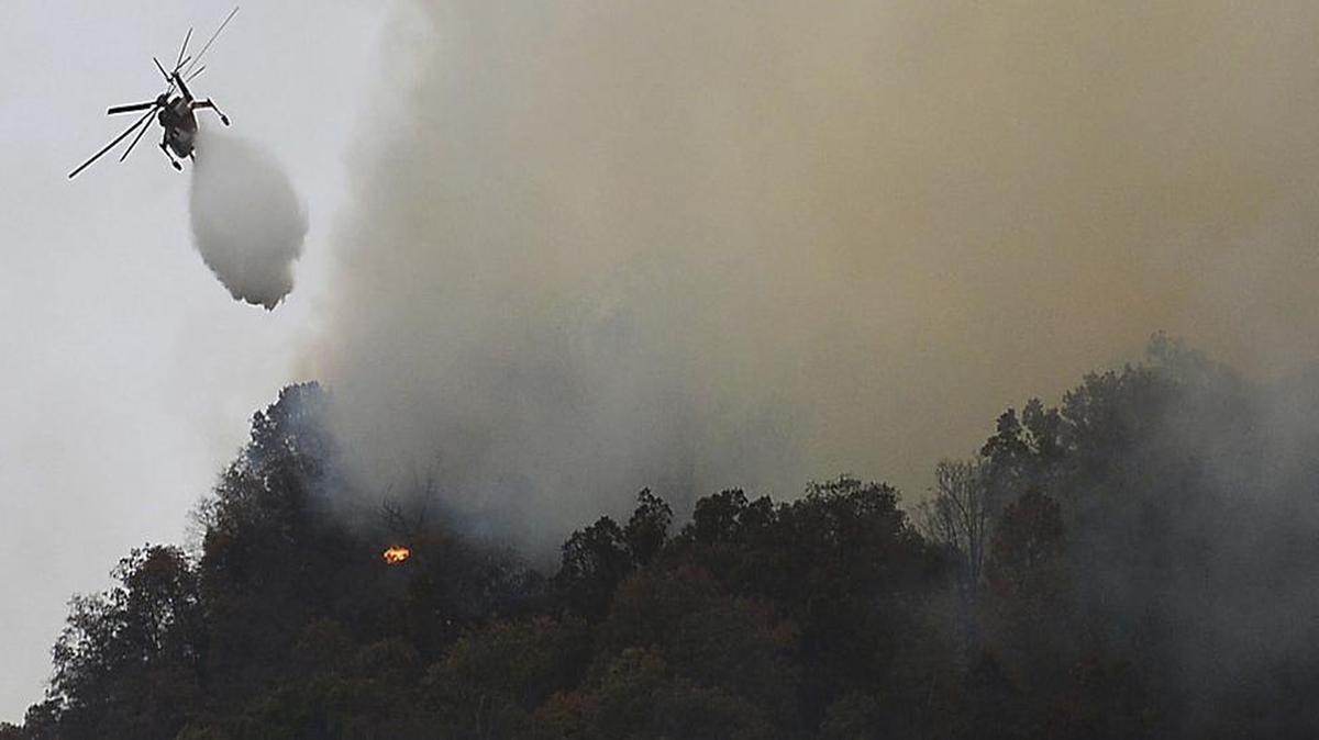 Crews work a wildfire near Lake Lure Friday, Nov. 11. State transportation officials say the wildfire near Lake Lure has forced the immediate closing of U.S. 64/74A and N.C. 9 in Rutherford County.