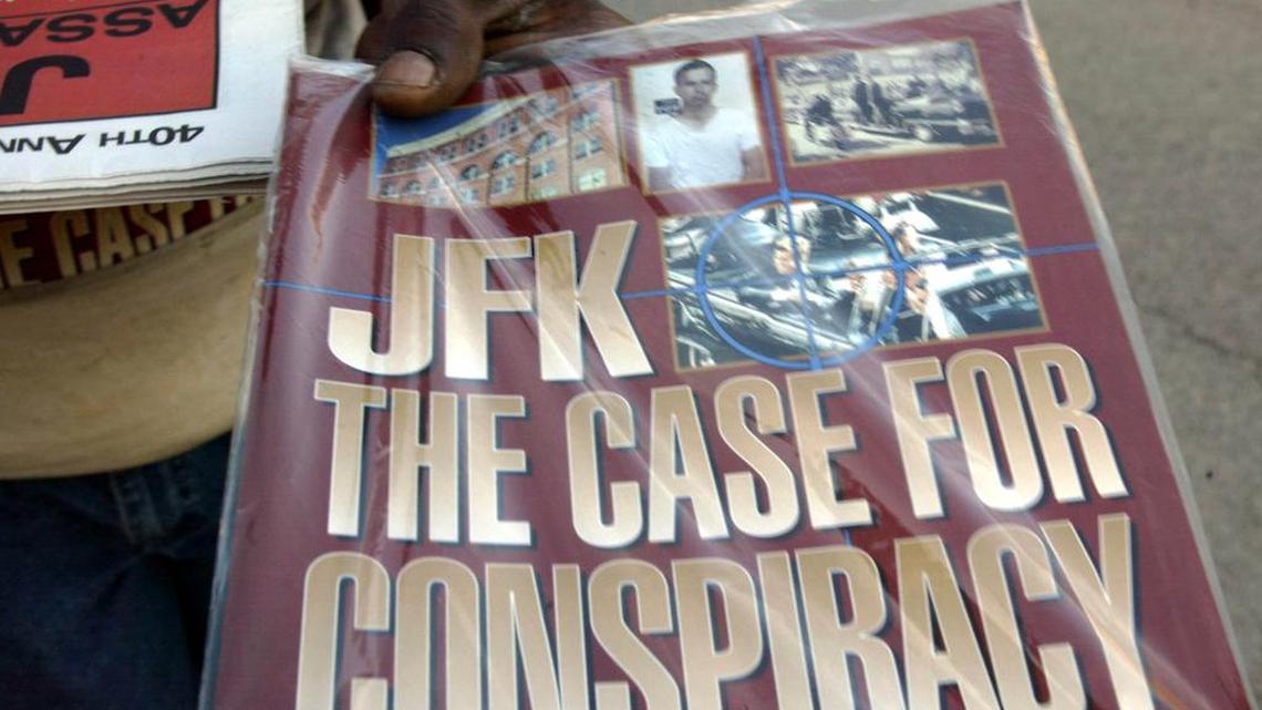 In this Saturday, Nov. 8, 2003 file photo, a vendor holds up a magazine-style publication titled "JFK The Case For Conspiracy" in downtown Dallas. On the very day John F. Kennedy died, a cottage industry was born. Fifty years and hundreds of millions of dollars later, it's still thriving. Its product? The "truth" about the president's assassination.