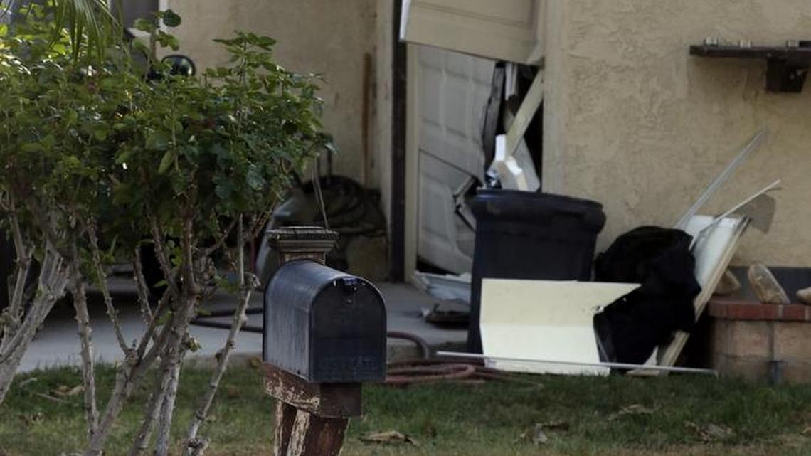 Damage to a home is shown Saturday after law enforcement raided it the prior night in connection with Wednesday's shooting rampage in Riverside, Calif. The Pakistani woman who joined her U.S.-born husband in killing multiple people in a commando-style assault on his co-workers is at the center of a massive FBI terrorism investigation, yet she remains shrouded in mystery.