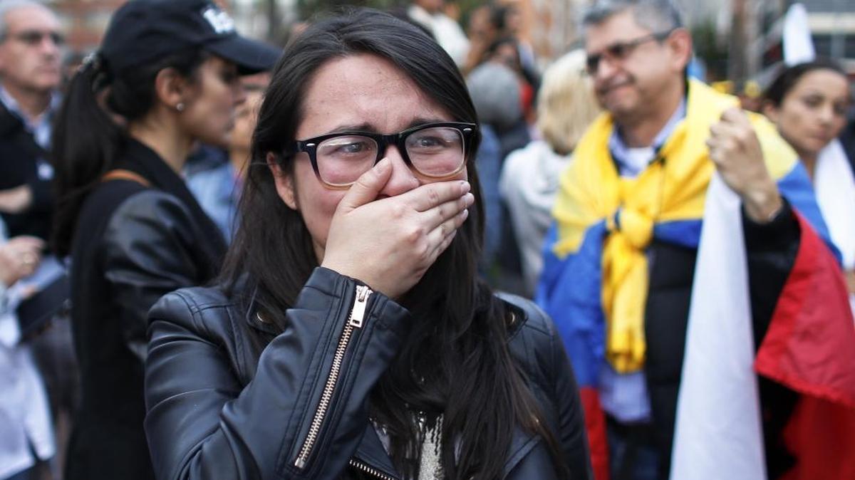A supporter of the peace accord signed between the Colombian government and rebels of the Revolutionary Armed Forces of Colombia, FARC, cries as she follows on a giant screen the results of a referendum to decide whether or not to support the deal in Bogota Sunday. Colombians rejected the deal by a razor-thin margin.