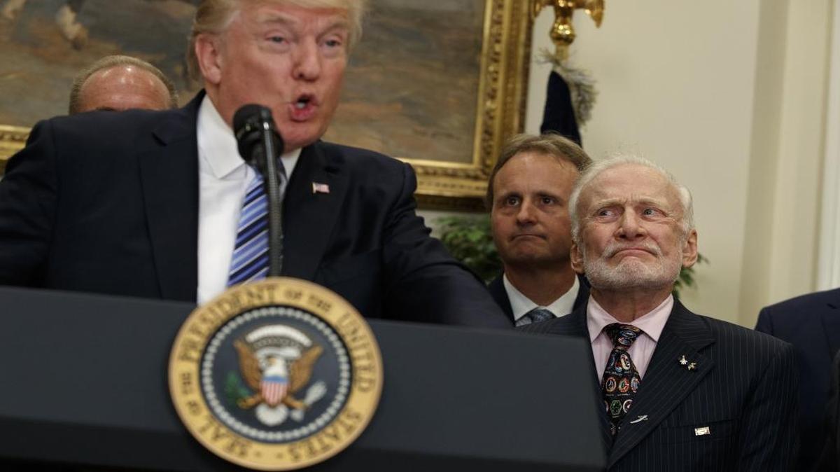 Former astronaut Buzz Aldrin listens at right as President Donald Trump speaks before signing an executive order to establish a National Space Council on Friday in the Roosevelt Room of the White House in Washington.