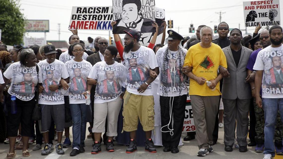
Michael Brown Sr., center, leads a march in remembrance of his son, Michael Brown Jr., on Sunday, Aug. 9, 2015, in Ferguson, Mo. Sunday marks one year since the 18-year-old was shot and killed by Ferguson police officer Darren Wilson. 
