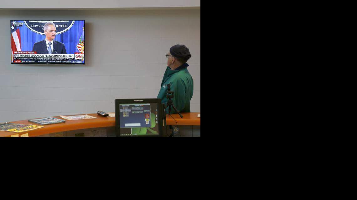 
Ank Ankenbrand, a 40-year resident of Ferguson. Mo., watches a television at the Ferguson Community Center Wednesday, March 4, 2015, in Ferguson, Mo., as U.S. Attorney General Eric Holder delivers the department's report on the patterns and practices of the Ferguson police department. 
