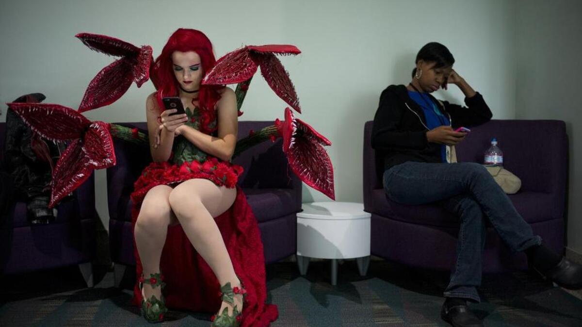 A woman dressed as comic book character Poison Ivy checks her smartphone while taking a short break at Stan Lee's Los Angeles Comic Con on Sunday, Oct. 30, 2016. Scientists say one swab from a smartphone’s touchscreen can tell them all about the owner’s lifestyle.