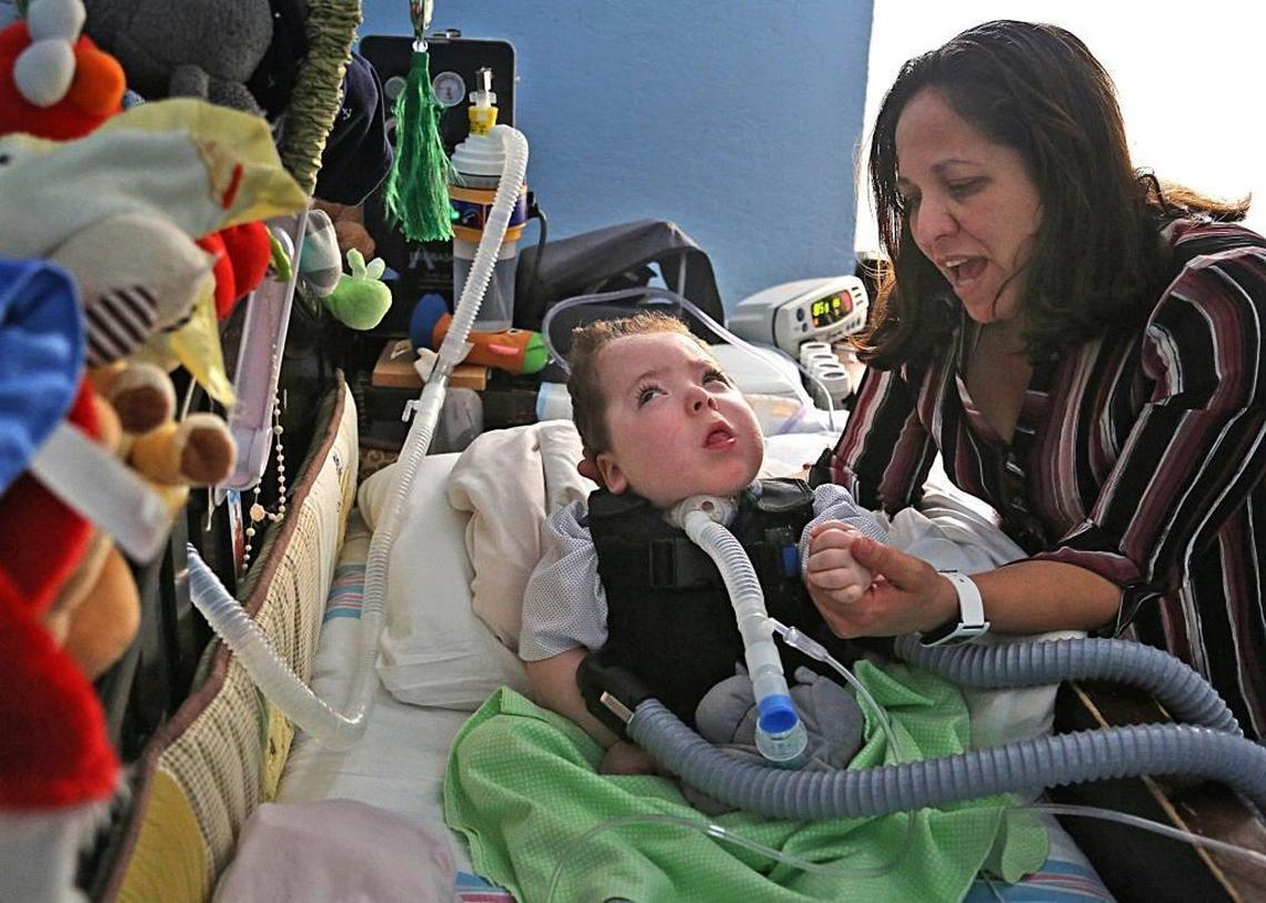 Alejandro Quesada, a 5-year-old old twin boy with a diagnosis of cortical visual impairment, bilateral retinopathy of prematurity, brain atrophy and optic atrophy, is attended by his mother Lizzette Jimenez, 46, right, as he lays inside his out dated crib on Thursday, December 21, 2017. Quesada is in need of a new medical bed, a special car chair, and other items due to medical condition.