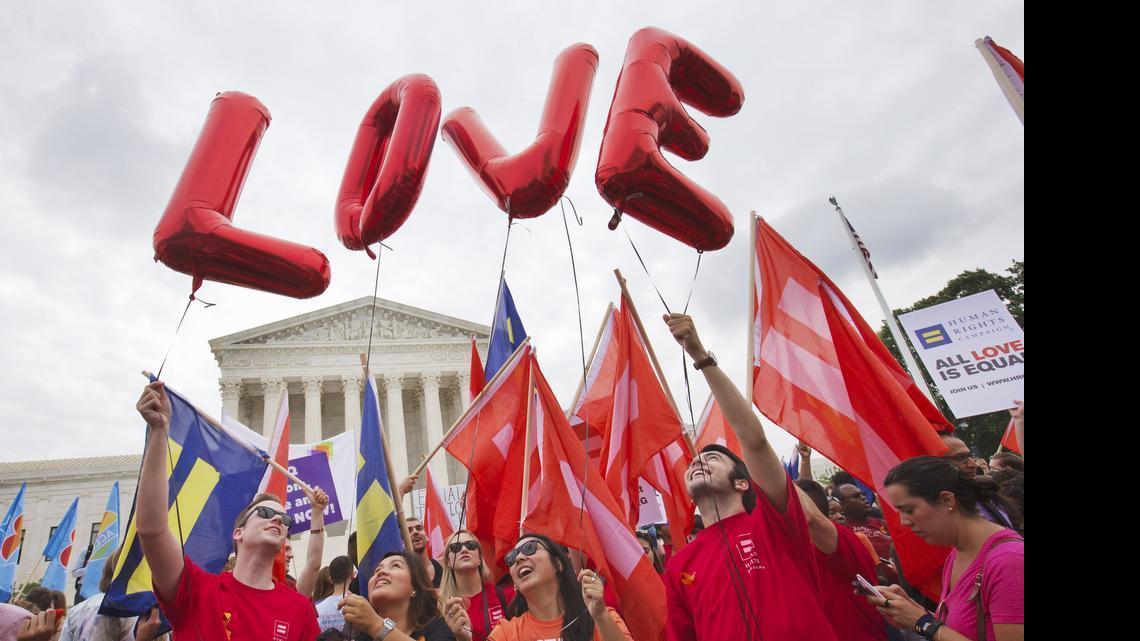 
Same-sex marriage supporters hold up balloons that spell the word "love" as they wait outside of the Supreme Court in Washington, Friday June 26, 2015, before the court declared that same-sex couples have a right to marry anywhere in the US.
