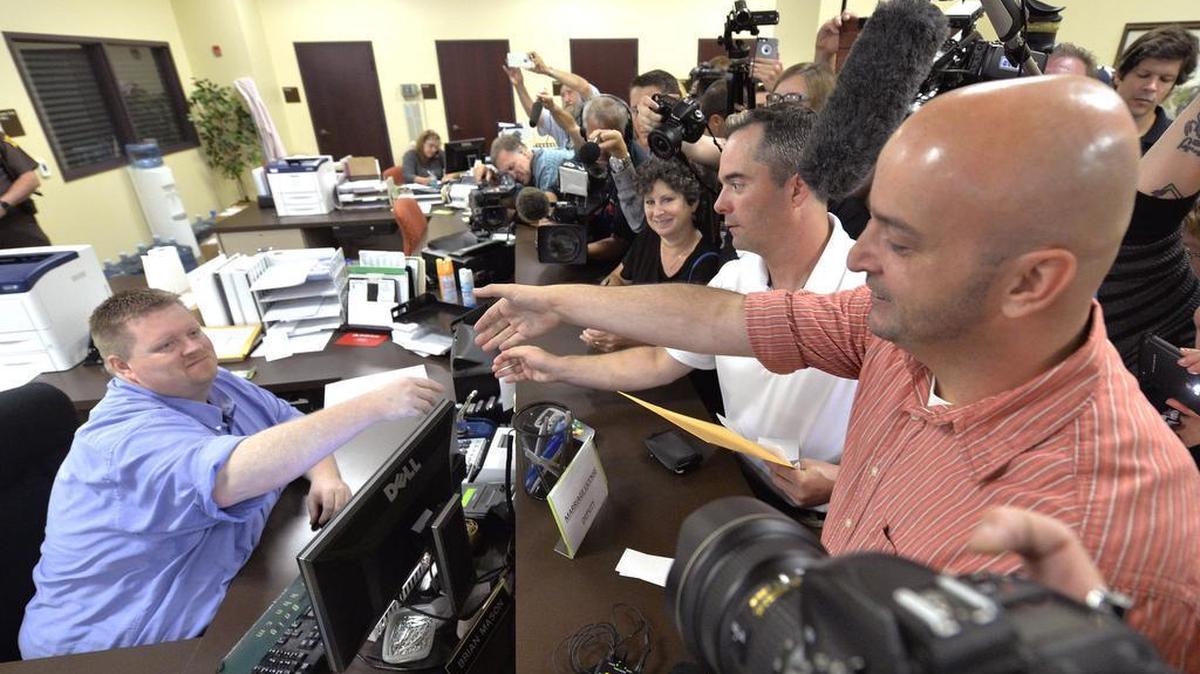 
Rowan County deputy clerk Brian Mason, left, shakes hands with James Yates, and his partner William Smith Jr., after issuing their their marriage license at the Rowan County Judicial Center in Morehead, Ky., Friday, Sept. 4, 2015. After four attempts, Yates and Smith were finally issued their marriage license. 
