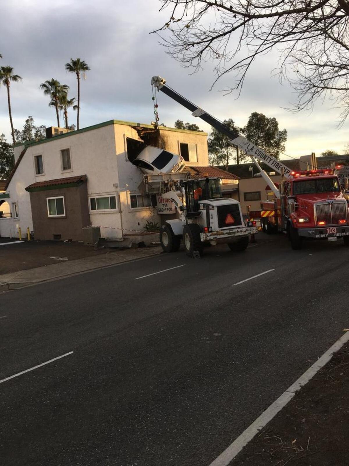A wrecker truck works to remove the car from the building in Santa Ana.